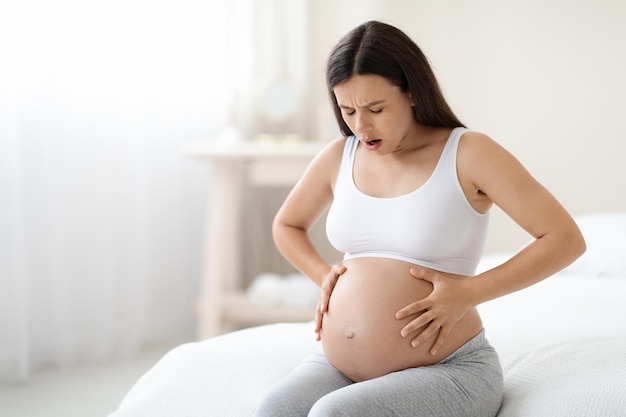 Mulher grávida que sofre de dor abdominal em casa copie o espaço