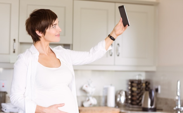 Mulher grávida que toma um selfie