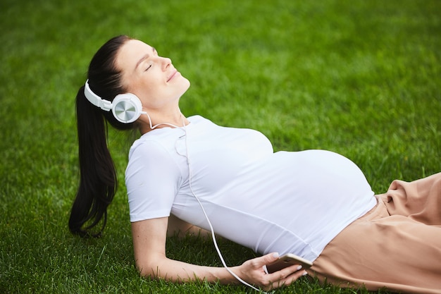 Mulher grávida relaxante na grama