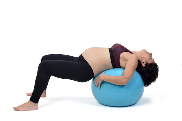 Mulher grávida se exercitando com uma bola no fundo branco