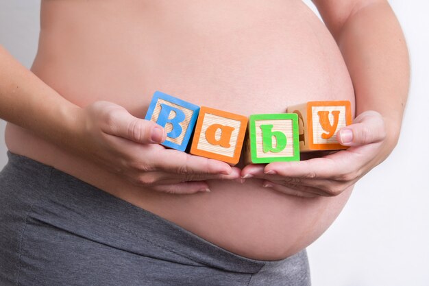 Mulher grávida segurando a palavra do bebê