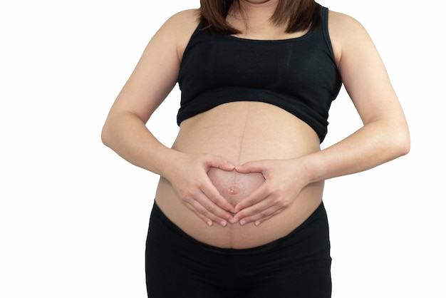 Mulher grávida segurando em sua barriga fazendo forma de coração de mão isolada em fundo branco Família mãe mãe mãe grávida conceito