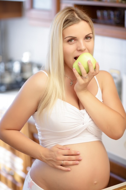 Mulher grávida, segurando, maçã verde, e, sorrindo