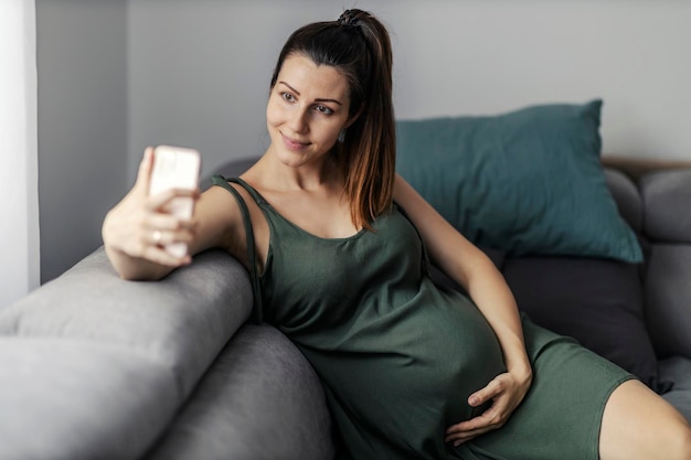 Mulher grávida tirando uma foto de relaxamento para uma mulher grávida