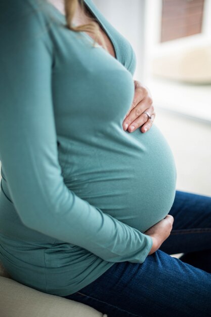 Mulher grávida, tocar, dela, barriga, sentar sofá