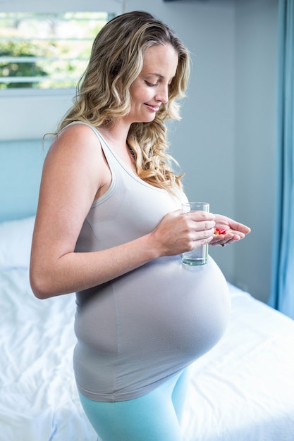 Mulher grávida, tomar um comprimido, com, água, em, dela, quarto