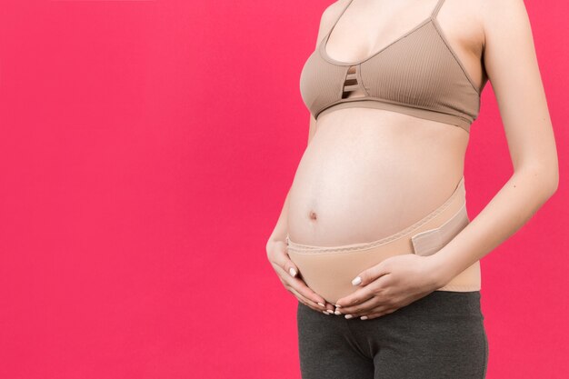 mulher grávida usando bandagem elástica contra dor nas costas