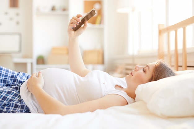 Mulher grávida usando smartphone