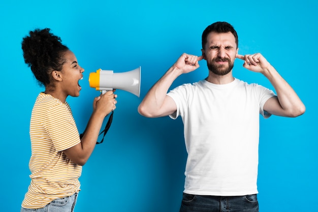 Foto mulher gritando com homem através de megafone