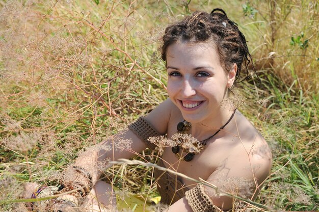 Mulher hippie alegre se divertindo relaxando em um prado selvagem