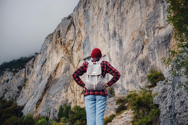 Mulher hipster asiática andando sozinha em uma estrada de montanha em um dia de neblina de outono