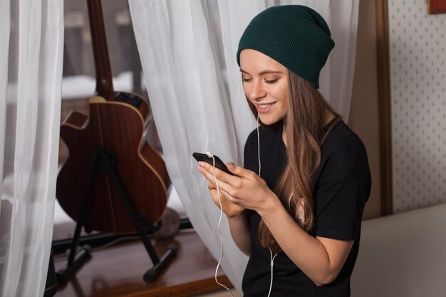 Mulher hipster de chapéu verde ouvindo música e curtindo a vida