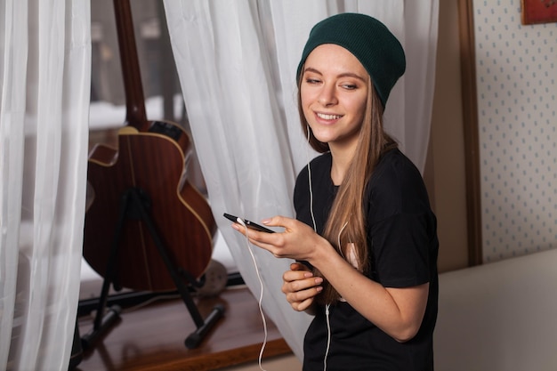 Mulher hipster de chapéu verde ouvindo música e curtindo a vida