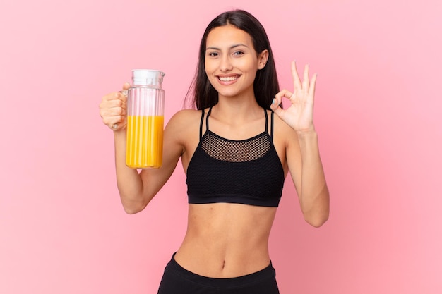 Mulher hispânica bonita com um suco de laranja