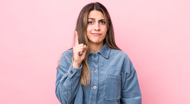 Mulher hispânica bonita se sentindo como um gênio segurando o dedo orgulhosamente no ar depois de perceber uma ótima ideia dizendo eureka