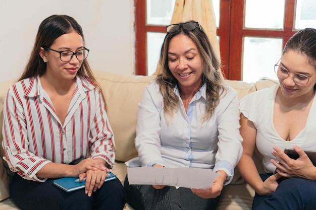 Mulher hispânica falando com um pequeno grupo na sessão de treinamento de escritório