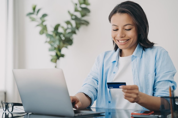 Mulher hispânica feliz usando cartão de crédito o cliente está gostando de fazer compras online com internet banking