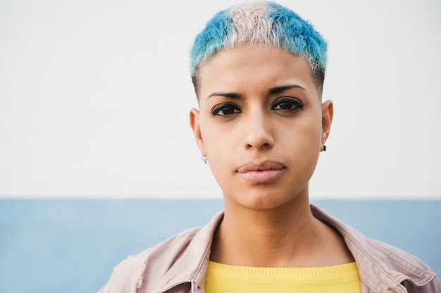 Foto mulher hispânica gay olhando para a câmera ao ar livre - foco no rosto