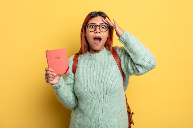 Mulher hispânica olhando feliz, surpreso e surpreso, estudante e conceito de calendário