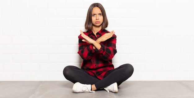 Mulher hispânica parecendo irritada e cansada de sua atitude, dizendo o suficiente! mãos cruzadas na frente, dizendo para você parar