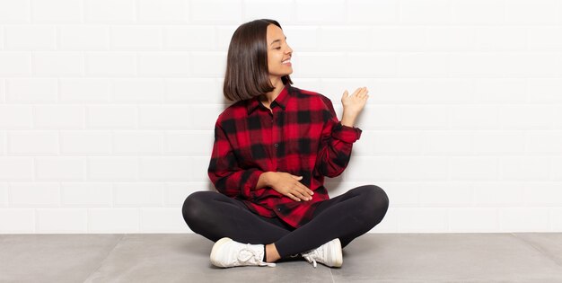 Mulher hispânica se sentindo feliz e alegre, sorrindo e recebendo você, convidando-o com um gesto amigável