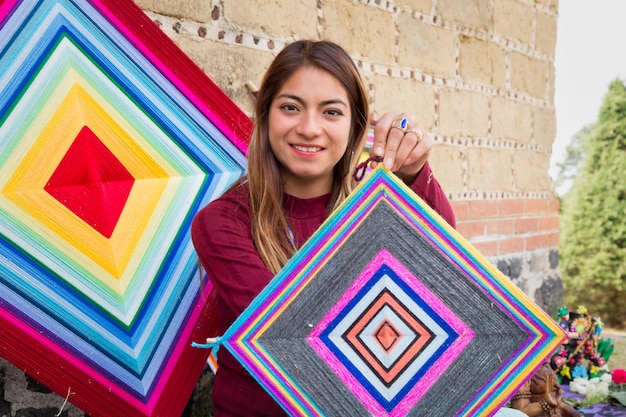 Mulher hispânica segurando uma mandala de tricô