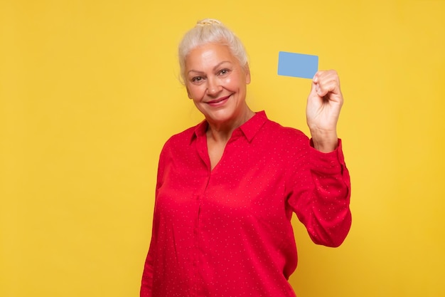 Mulher hispânica sênior sorrindo mostrando o cartão em branco