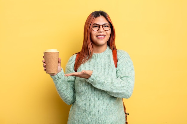 Mulher hispânica sorrindo alegremente, sentindo-se feliz e mostrando um conceito. estudante com um conceito de café