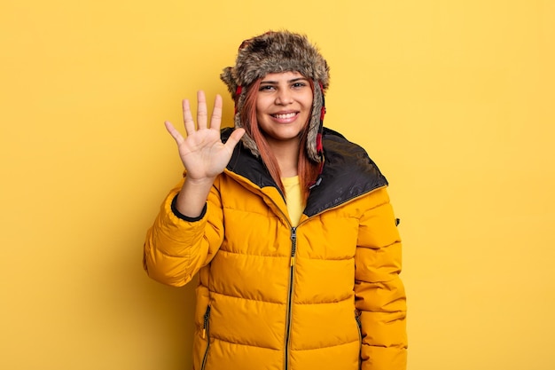 Mulher hispânica sorrindo e parecendo amigável mostrando o conceito de inverno número cinco