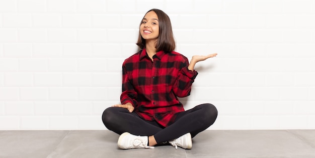 Foto mulher hispânica sorrindo, sentindo-se confiante, bem-sucedida e feliz, mostrando o conceito ou ideia no espaço da cópia ao lado