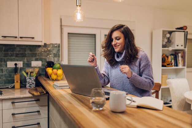 Mulher hispânica usando um laptop enquanto trabalhava em casa