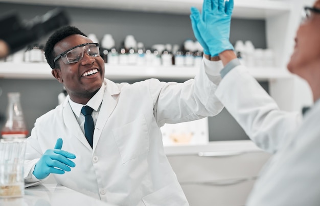 Mulher homem cientista e cinco no sorriso de laboratório ou parceria para resultados de metas ou inovação com trabalho em equipe de especialistas em ciências africanas e parabéns pelo sucesso na pesquisa médica