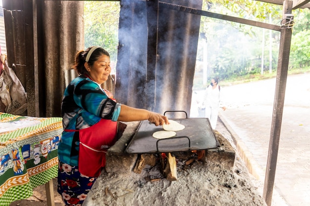 Mulher humilde da Nicarágua cozinhando tortilhas