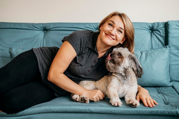 Foto mulher idosa acariciando seu cachorro