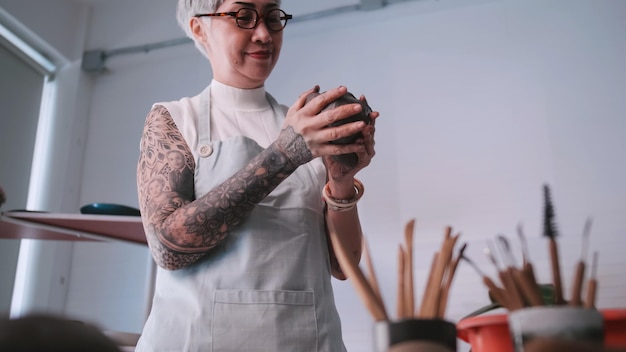 Foto mulher idosa asiática desfrutando do trabalho de cerâmica em casa uma ceramista feminina está fazendo nova cerâmica em um estúdio