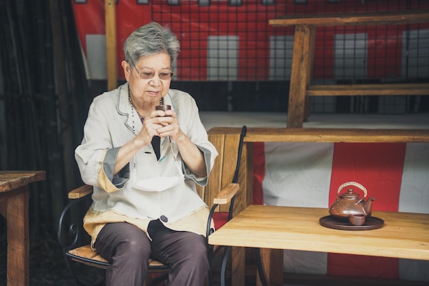 Foto mulher idosa asiática idosa bebendo chá no estilo de vida de lazer sênior do jardim