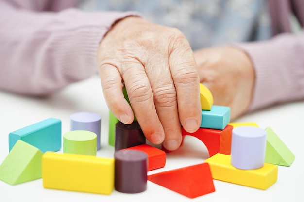 Mulher idosa asiática jogando quebra-cabeças para praticar treinamento cerebral para prevenção de demência Doença de Alzheimer