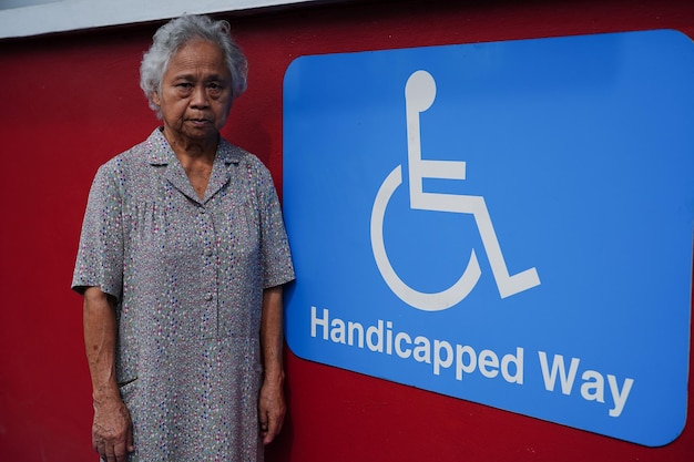 Mulher idosa asiática paciente com símbolo de pessoa com deficiência