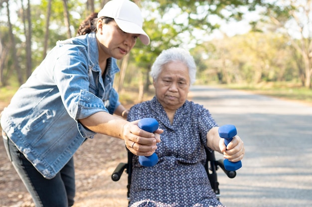 Mulher idosa asiática se exercita com halteres no parque