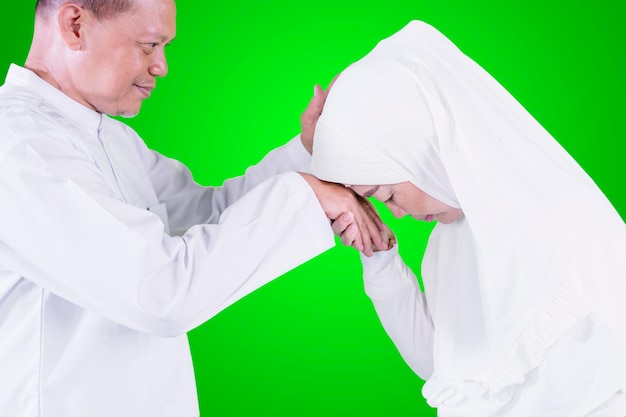 Mulher idosa beijando as mãos do marido durante o Eid Mubarak