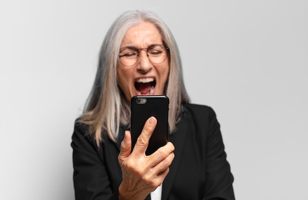 Mulher idosa bonita com um telefone inteligente