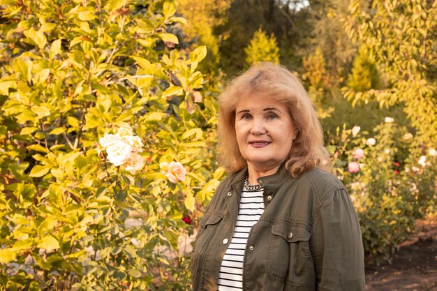 Mulher idosa caminhando em um parque verde, feliz aposentadoria