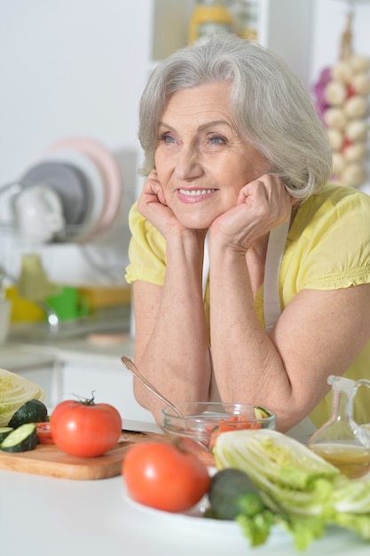 Foto mulher idosa com cabelos grisalhos cozinhando na cozinha
