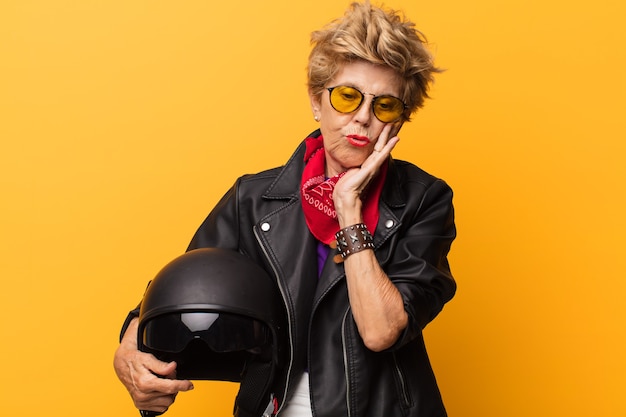 Mulher idosa com casaco de espuma e capacete de motociclista