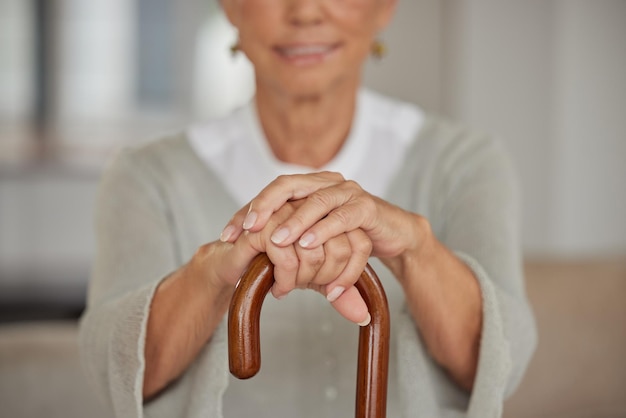 Mulher idosa com deficiência segurando uma bengala dentro de um lar de idosos Closeup de senhora idosa segurando um auxílio para caminhar relaxando em uma unidade de saúde enquanto usa uma muleta para apoio em casa de repouso