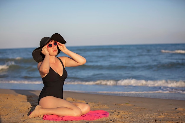 Mulher idosa de chapéu toma sol