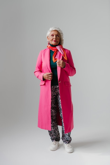 Mulher idosa elegante de comprimento completo com roupas elegantes que irradiam confiança e amor próprio.