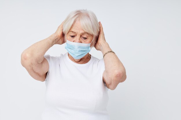 Mulher idosa em camiseta casual e máscara médica fechada