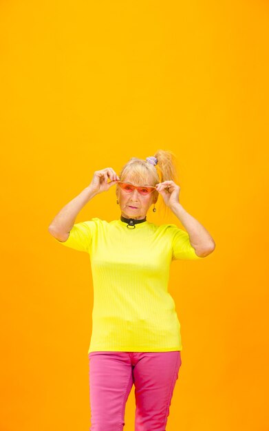 Mulher idosa em traje ultramoderno isolado em laranja brilhante