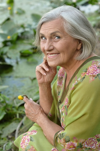 Mulher idosa em um verão perto do lago